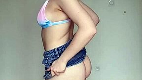 Hey, check out this skinny brunette with pierced nipples in a skirt and swim bra!