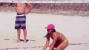 young girl struts a tiny bikini on the beach while boyfriend’s relatives watch.