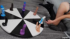 She desperately wants to win her orgasm on the wheel of dildos