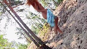 Stunning redhead teen model poses naked in the forest setting