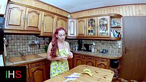 Redhead teen masturbates with fruit and dildos in kitchen before riding cock