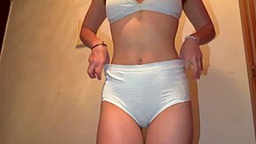 Cute girl tries on new panties while looking in the mirror