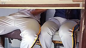 In a forbidden classroom game, the hot college girl flashes her uniform. She rides the desk wildly in a quickie with her student friend.