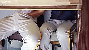 In a forbidden classroom game, the hot college girl flashes her uniform. She rides the desk wildly in a quickie with her student friend.